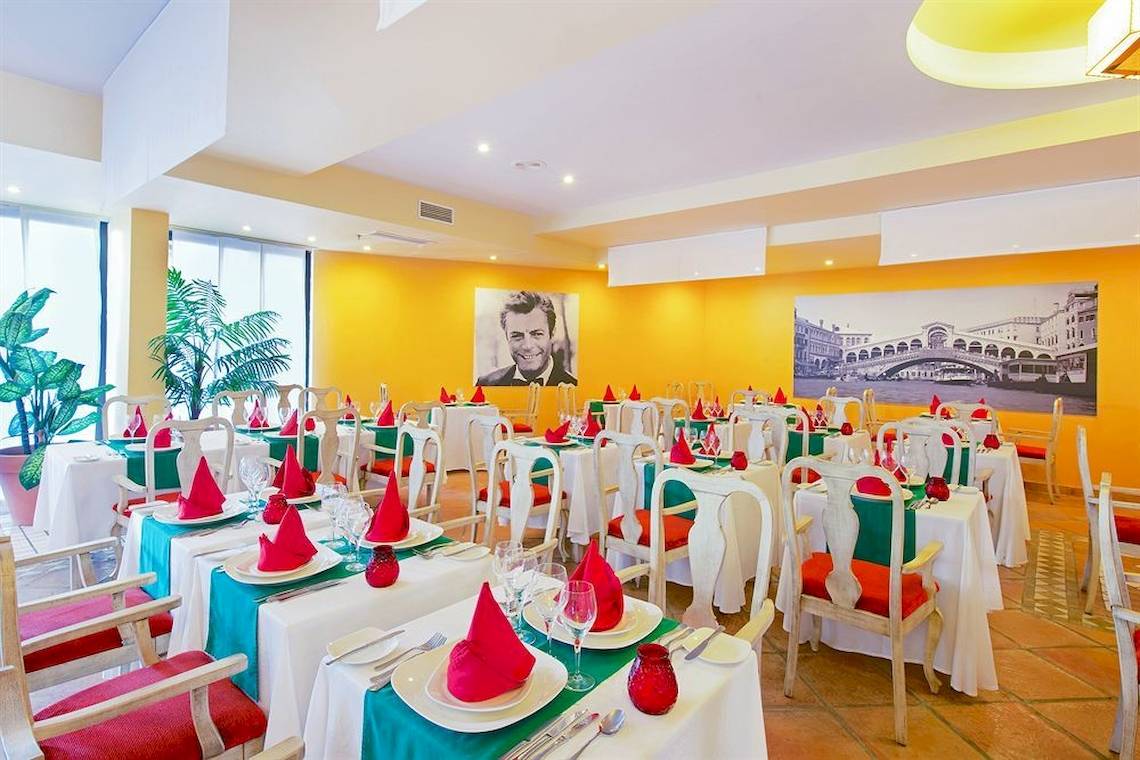 Innenansicht des Restaurants im Iberostar Playa Gaviotas Hotel mit gedeckten Tischen und gelben Wänden.