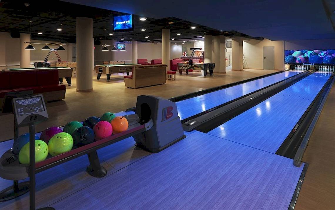Bowlinghalle im Hotel mit Bowlingbahnen, Billardtischen und Fernsehern.