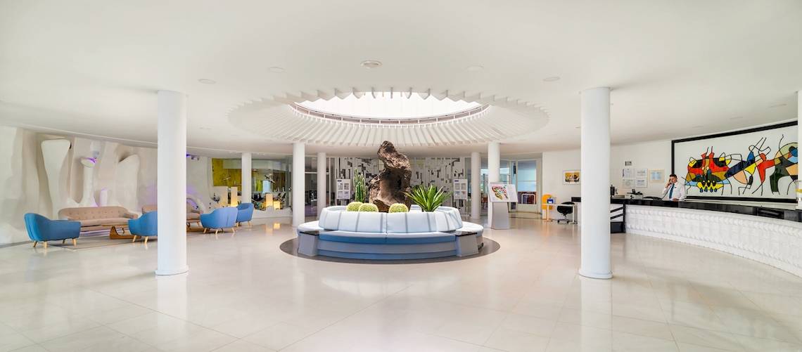 Lobby des H10 Suites Lanzarote Gardens Hotels mit moderner Inneneinrichtung und zentralem Brunnen.