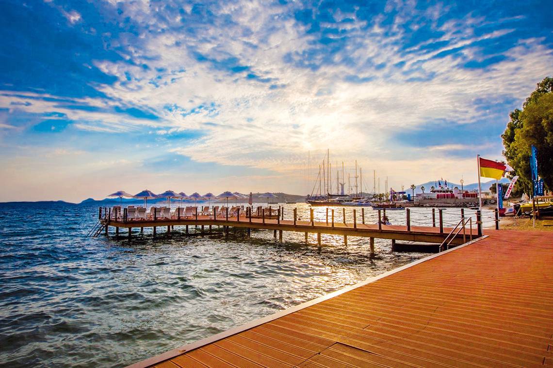 Pier am Meer mit Sonnenuntergang und Hotel LABRANDA TMT Bodrum im Hintergrund.