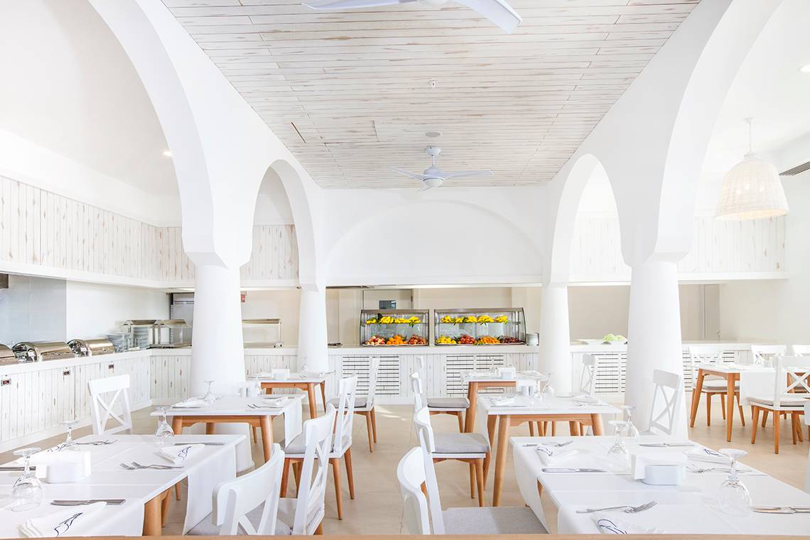 Innenraum des LABRANDA TMT Bodrum Restaurants mit weißen Tischen und Stühlen.