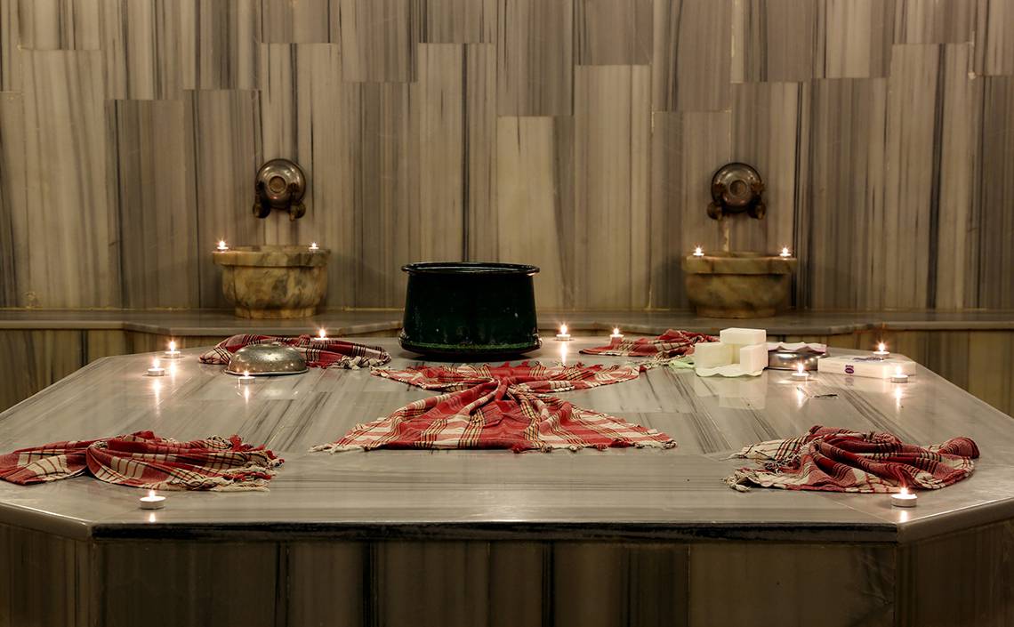 Innenansicht des Wellnessbereichs im LABRANDA TMT Bodrum Hotel mit einem Tisch, Kerzen und einem Becken.