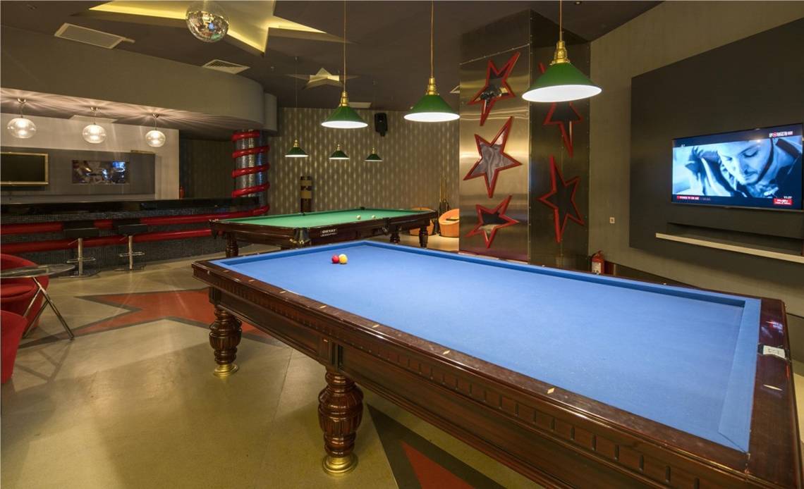 Pool-Lounge im Maxx Royal Belek Golf Resort mit zwei Billardtischen und Fernseher.