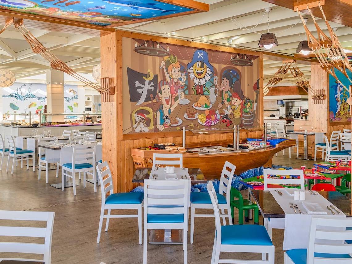 Innenansicht des Restaurants im H10 Suites Lanzarote Gardens mit buntem Wandbild und gedeckten Tischen.