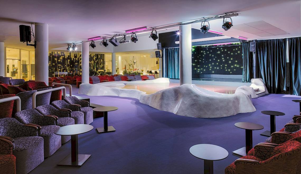 Loungebereich im H10 Suites Lanzarote Gardens mit weißen Möbeln und violettem Boden.