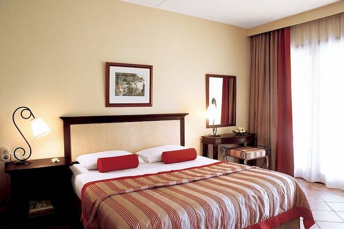 Schlafzimmer im Veranda Paul et Virginie Hotel mit Doppelbett, Nachttischen und Dekor.