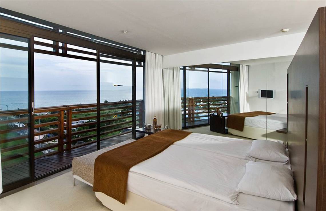 Hotelzimmer des Nirvana Cosmopolitan mit Blick auf das Meer und eine Terrasse.