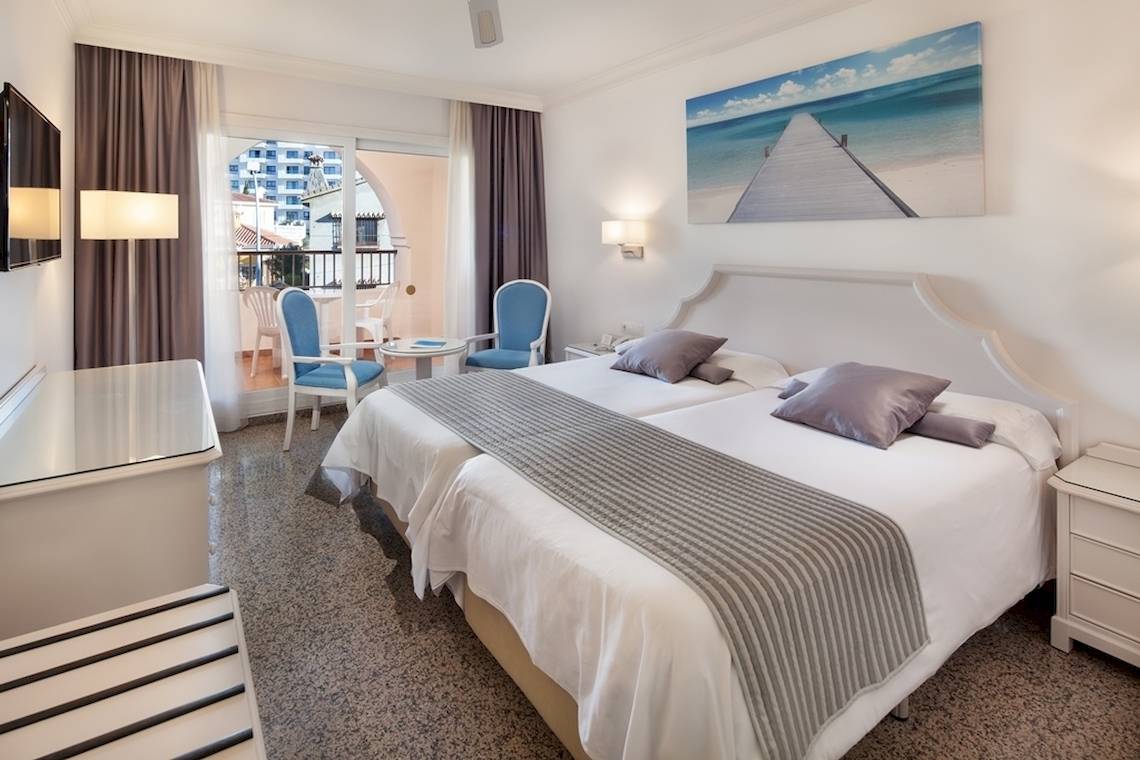 Doppelbettzimmer im MAC Puerto Marina Hotel mit Blick auf einen Balkon.