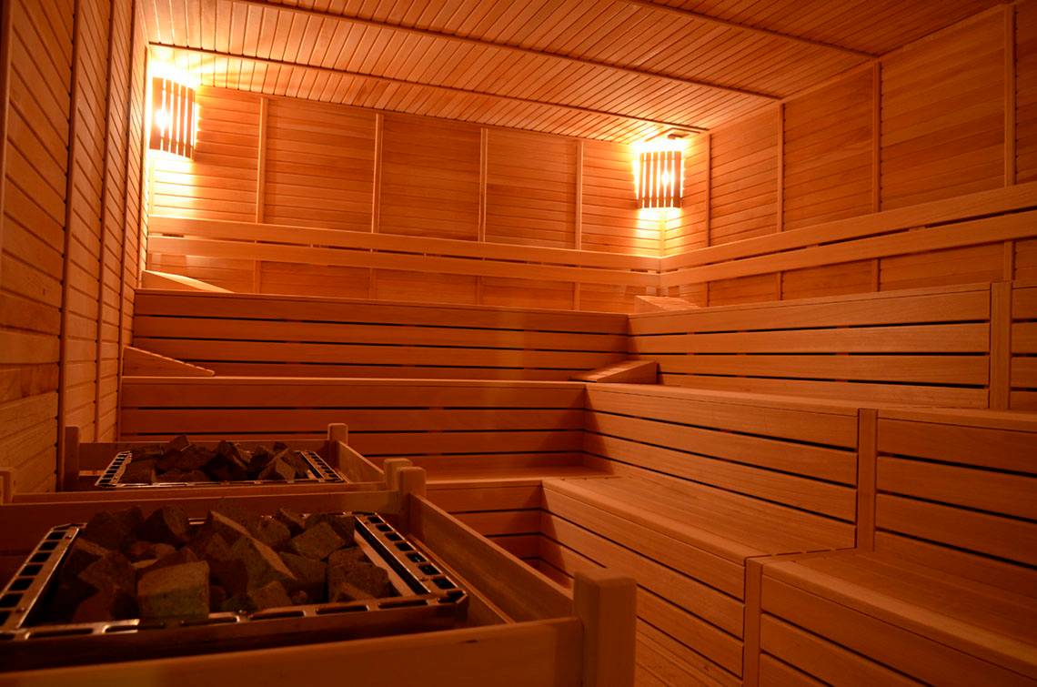 Sauna im Port Side Resort mit Holzwänden und zwei Holzkohlebecken.