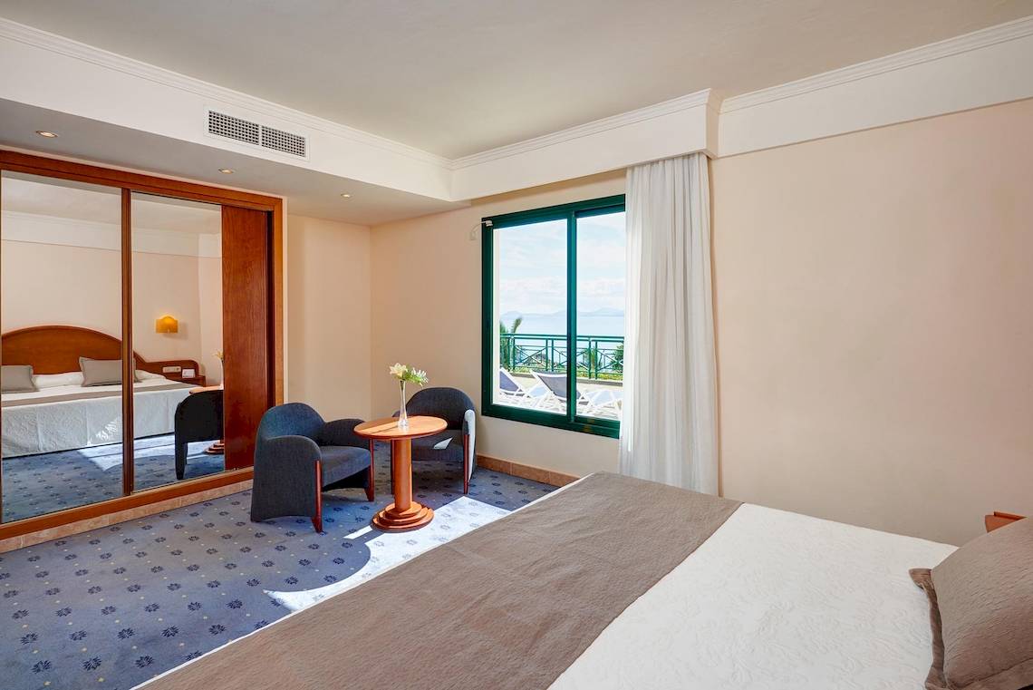 Hotelzimmer im Hipotels Natura Palace mit Meerblick, zwei Betten, einem Tisch und Stühlen.