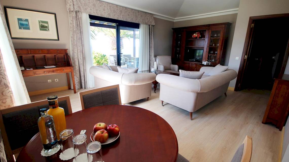 Wohnzimmer des Hipotels Natura Palace mit Sofas, Tisch und Früchten.
