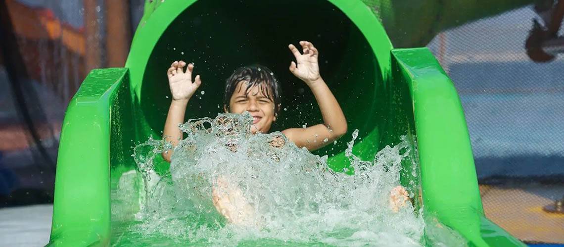 Ein junger Gast des DoubleTree by Hilton Resort & Spa Marjan Island genießt eine Wasserrutsche.