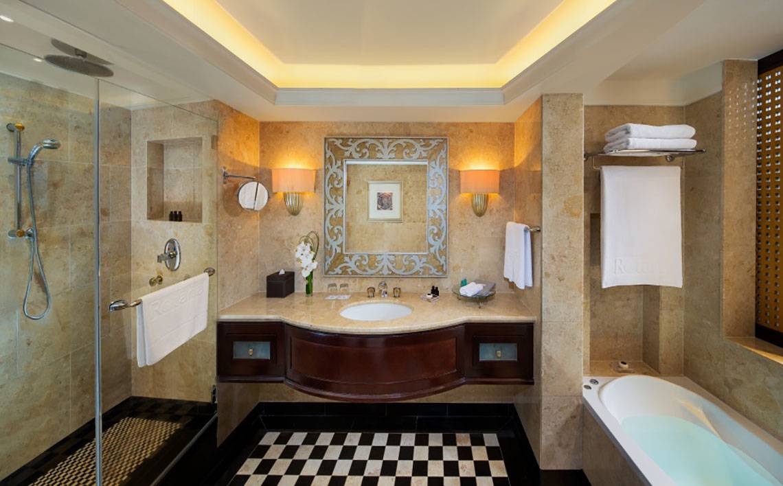 Badezimmer im Beach Rotana Hotel mit Badewanne, Dusche und Waschbecken.
