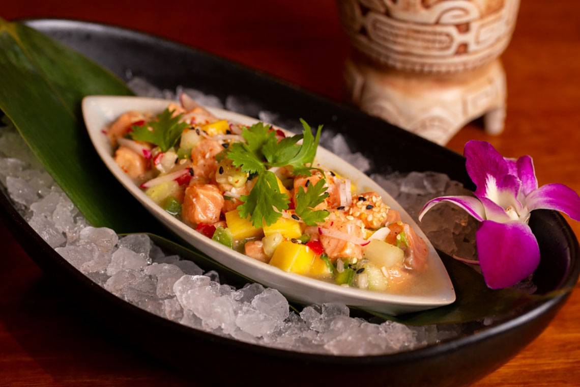 Fischsalat auf Eis serviert mit einer Blüte auf einem grünen Blatt