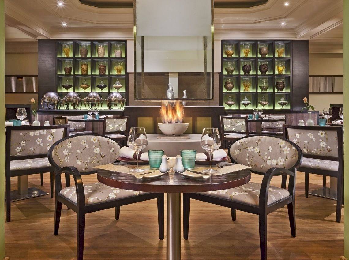 Innenansicht des Restaurants im Palmeraie Palace Hotel mit runden Tisch, Gläser und Teller.
