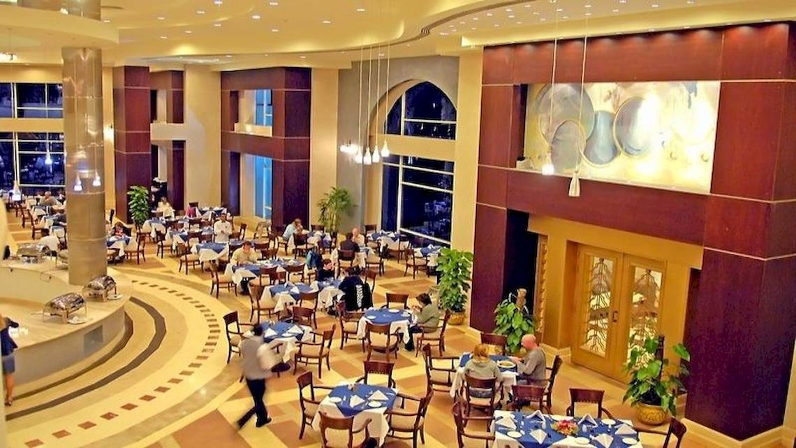 Ein Speisesaal im Serenity Alpha Beach Hotel mit vielen Gästen an Tischen.