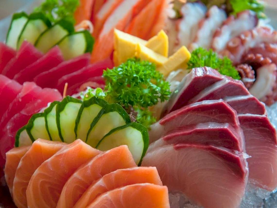 Eine Auswahl verschiedener Fischplatten, einschließlich Thunfisch, Lachs und Tintenfisch, auf Eis serviert.