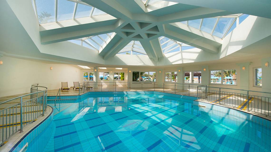 Innenpool des Iberostar Creta Panorama & Mare Hotels mit Glasdach und Sitzbereich