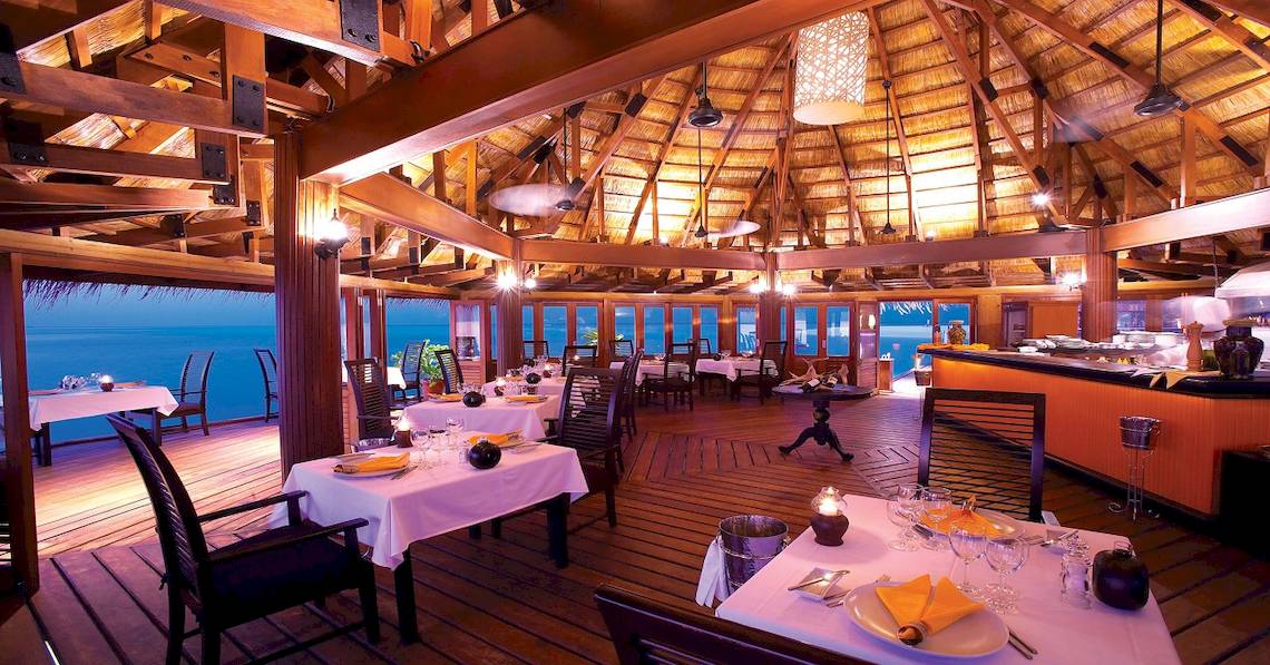 Innenansicht des Restaurants im Angsana Velavaru mit Blick auf das Meer und gedeckten Tischen.
