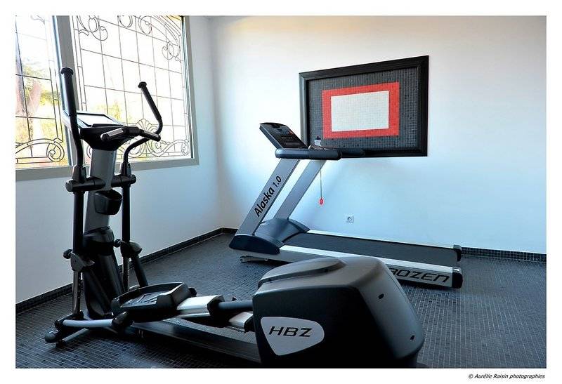 Fitnessraum im Boutique Hotel Liberata mit Läufer und Crosstrainer neben Fenster