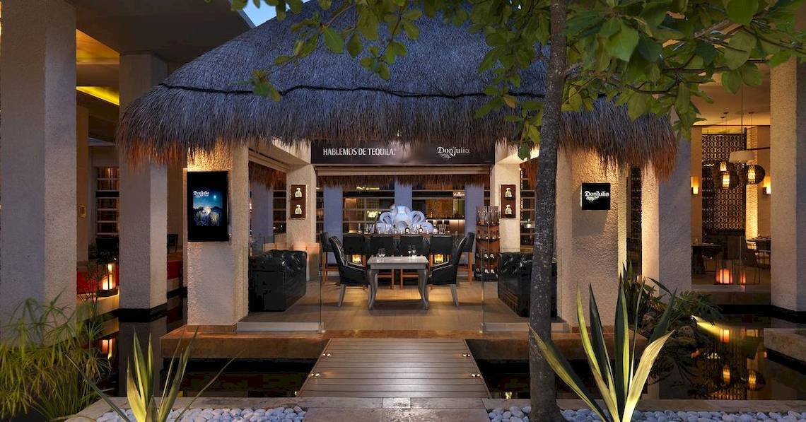Außenbereich des Paradisus Playa del Carmen Hotels mit einem Tisch und Stühlen.