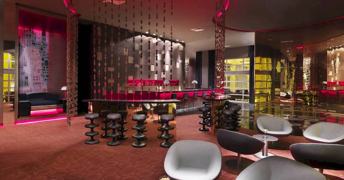Innenbereich der Bar im Paradisus Playa del Carmen Hotel mit moderner Einrichtung und roten Lichtern.