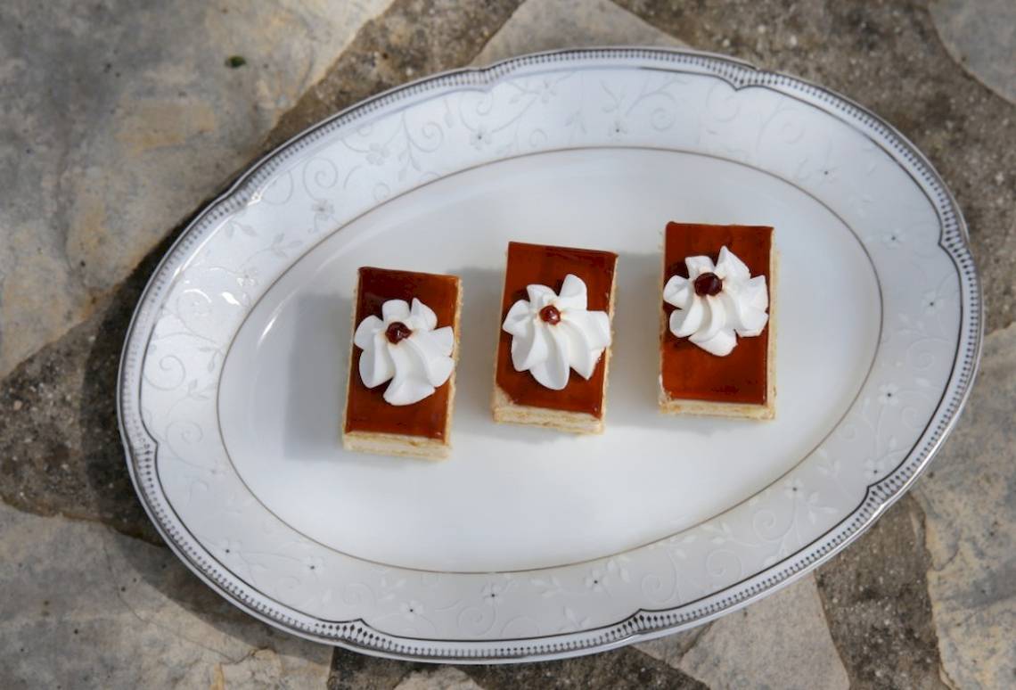 Dreieckigere Sahne-Desserts auf einem weißen Teller serviert