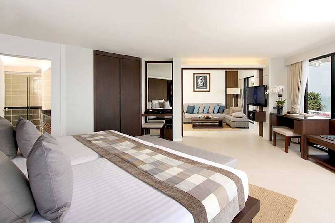 Schlafzimmer im Cape Panwa Hotel mit Doppelbett, Fernseher und Wohnzimmer.