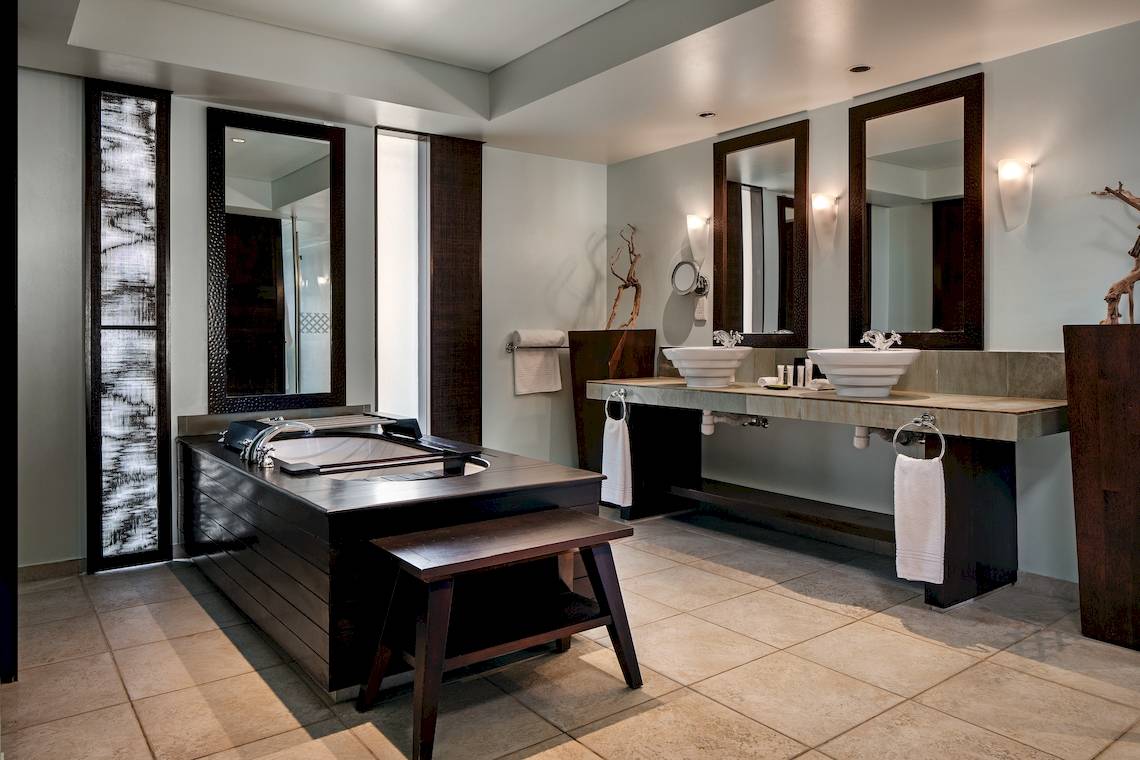 Badezimmer im Fisherman's Cove Resort mit Badewanne, Waschbecken und Spiegeln.