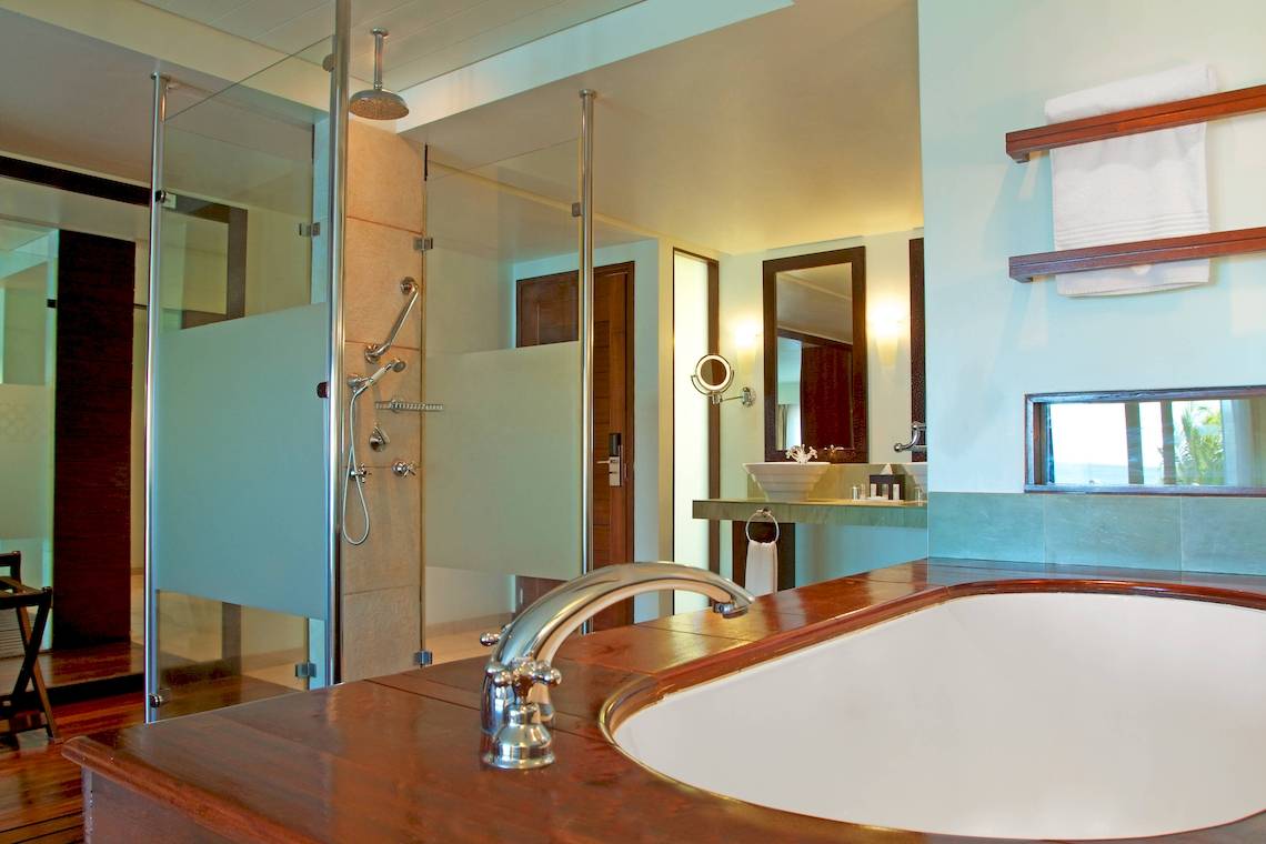 Badezimmer im Fisherman's Cove Resort mit Regendusche, Badewanne und Spiegeln.