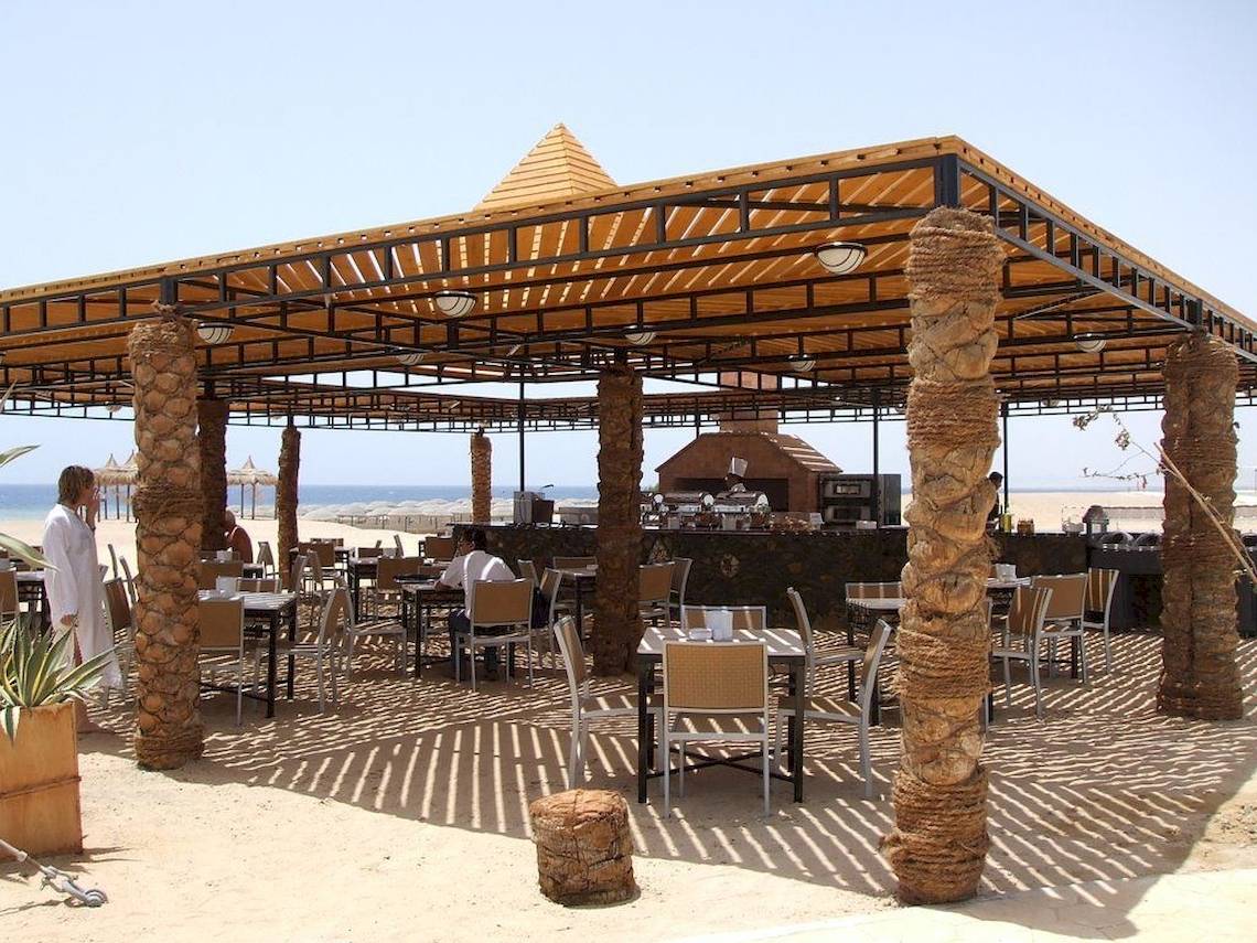 Außenterrasse des Gorgonia Beach Resorts mit Tischen und Stühlen unter einem Dach