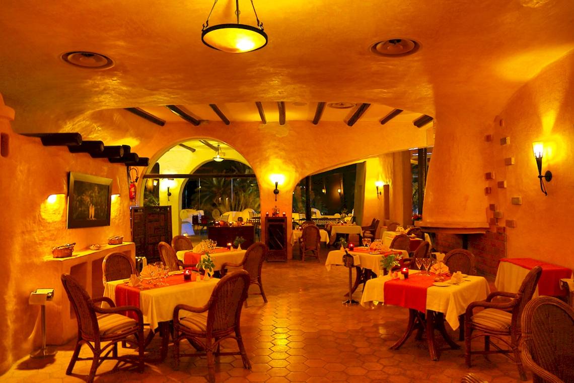 Innenansicht des Restaurants im Odyssee Resort Thalasso & Spa mit gedeckten Tischen und warmer Beleuchtung.