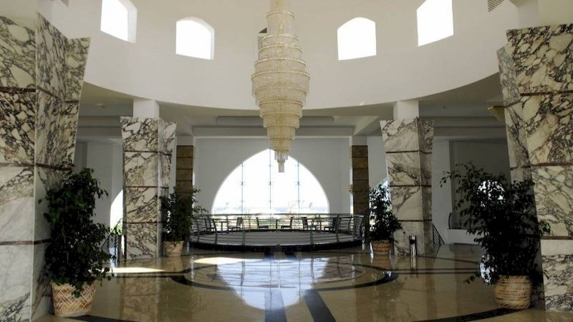 Foyer des Gorgonia Beach Resorts mit hohen Säulen, Kronleuchter und Pflanzen in Töpfen.