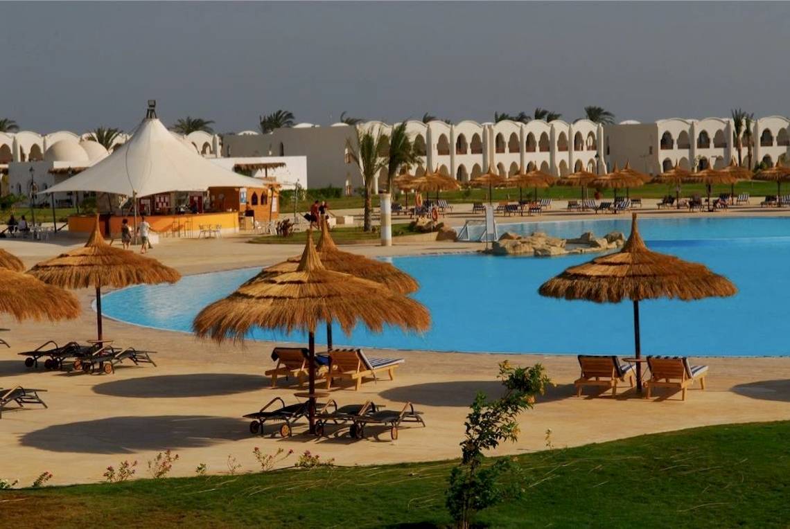 Außenbereich des Gorgonia Beach Resorts mit Pool, Liegestühlen und Sonnenschirmen.