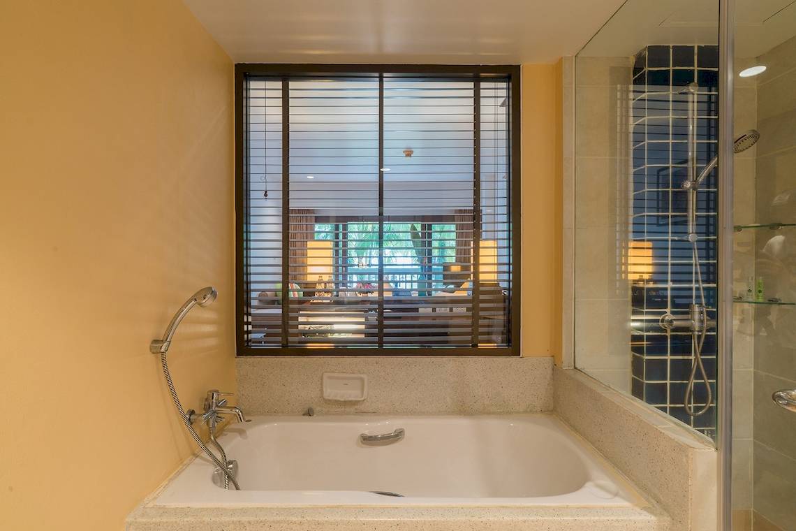 Badezimmer mit Badewanne und Fenster im Briza Beach Resort