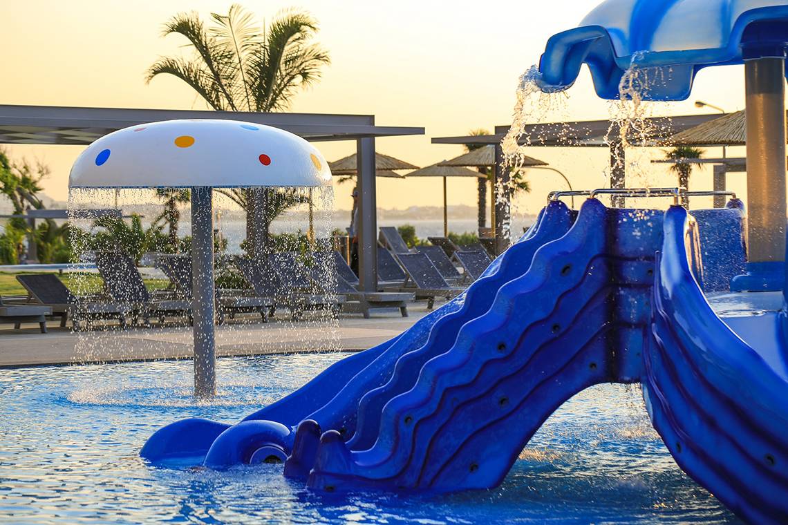 Blaue Wasserrutsche im Schwimmbad des Akti Imperial Deluxe Resort mit Wasserfontäne