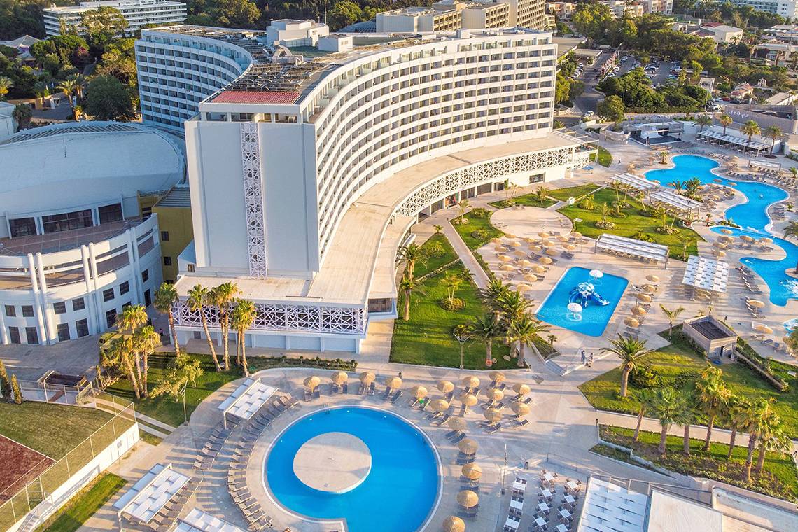 Luftaufnahme des Akti Imperial Deluxe Resort & Spa Dolce by Wyndham mit mehreren Swimmingpools und Sonnenliegen.