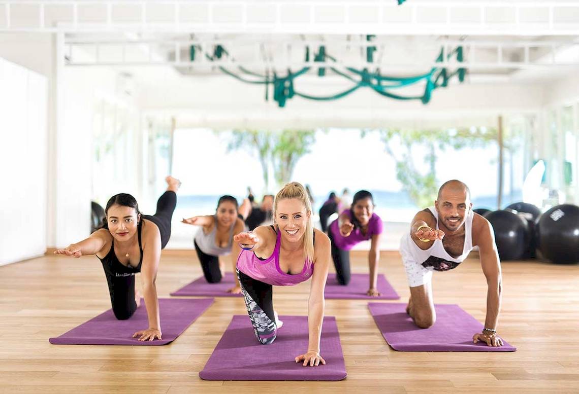 Gruppe von Menschen, die Yoga im Kandima Maldives Hotel machen