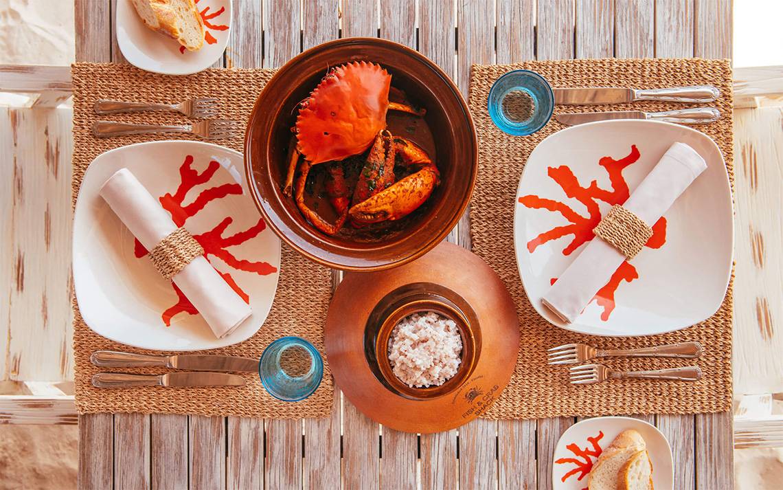 Ein Tisch mit Essen im Hotel Finolhu Baa Atoll Maldives, inklusive Teller, Krabbensuppe, Reis und Besteck.