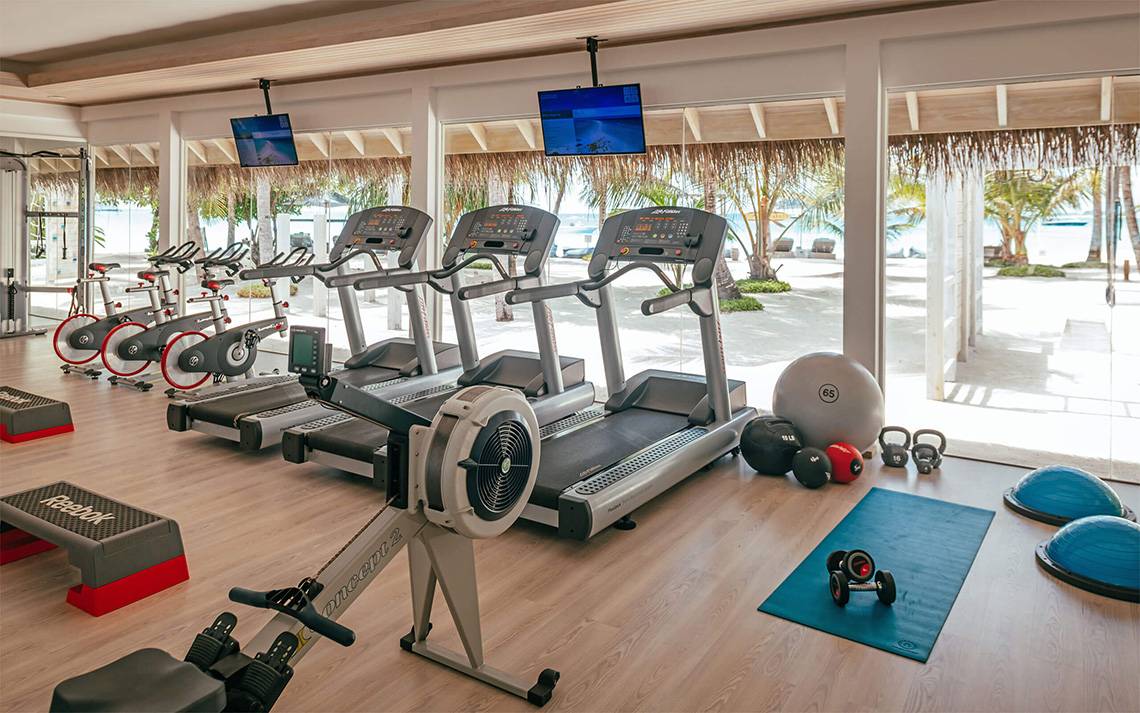 Fitnessstudio im Finolhu Baa Atoll Maldives mit Blick auf den Strand und Palmen.