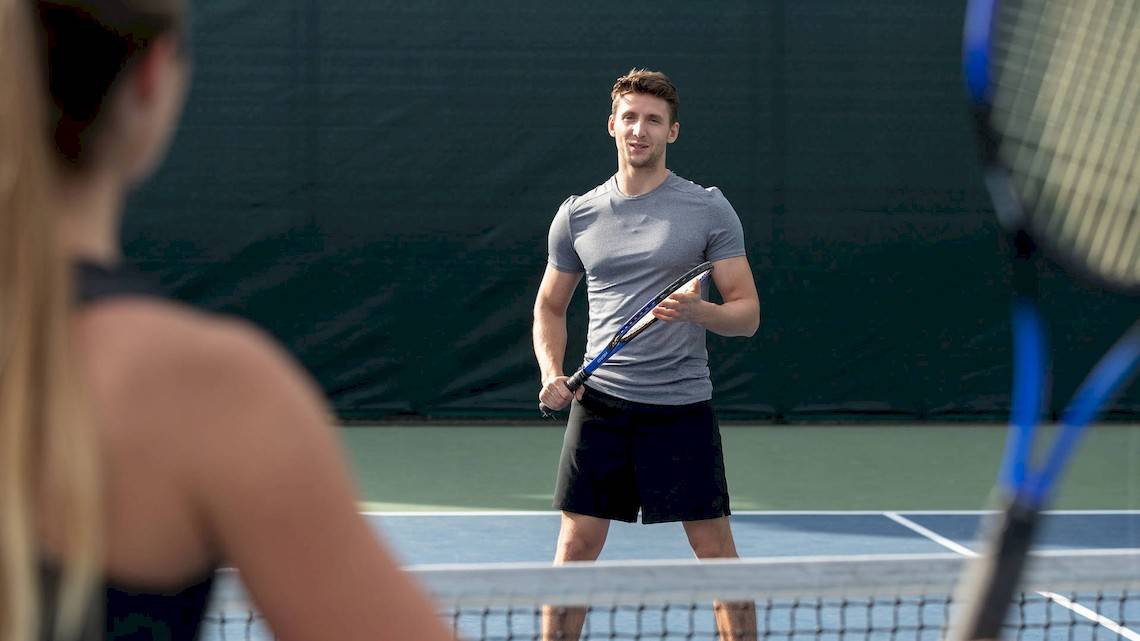 Tennisspieler im grauen T-Shirt und schwarzen Shorts auf einem Tennisplatz im Jumeirah at Saadiyat Island Resort