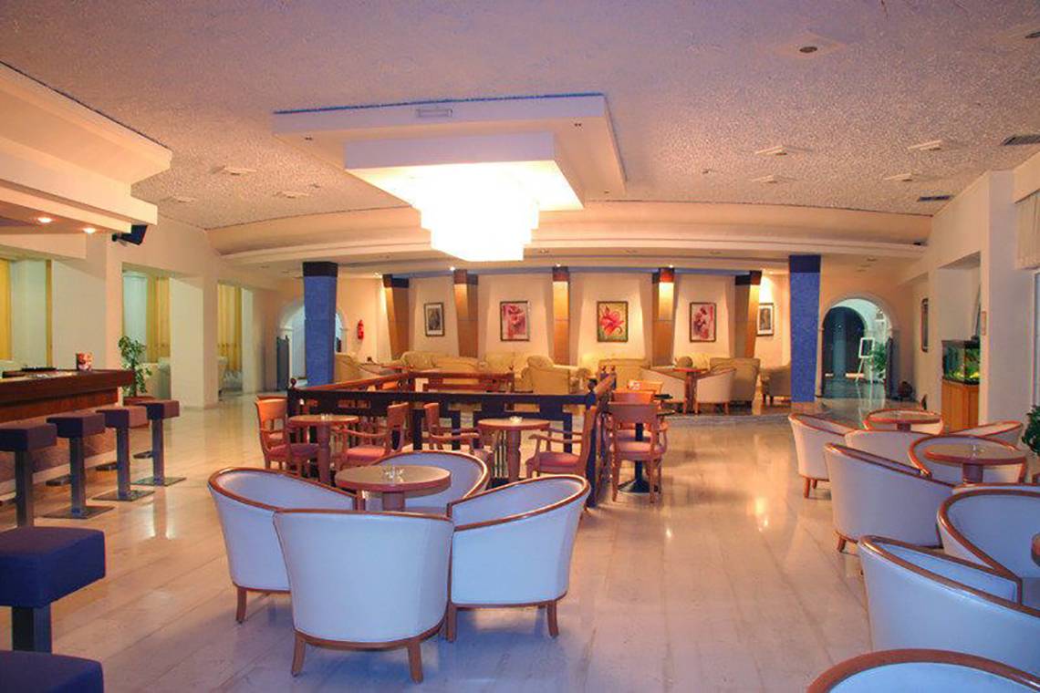 Lobby des Atlantis Beach Hotels auf Kos mit Sitzgelegenheiten und Bar.