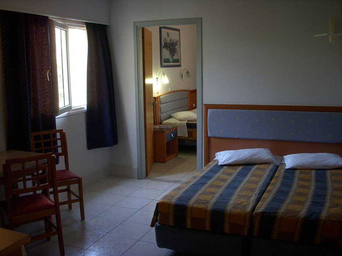 Doppelzimmer im Atlantis Beach Hotel in Kos mit zwei Betten, Tisch und Stühlen.