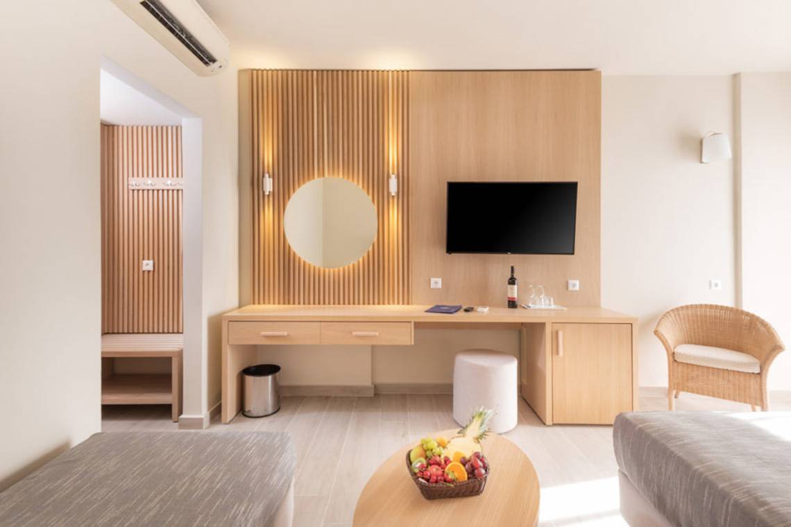 Innenansicht eines Zimmers im Horizon Beach Resort mit Schreibtisch, Fernseher und Obstkorb.