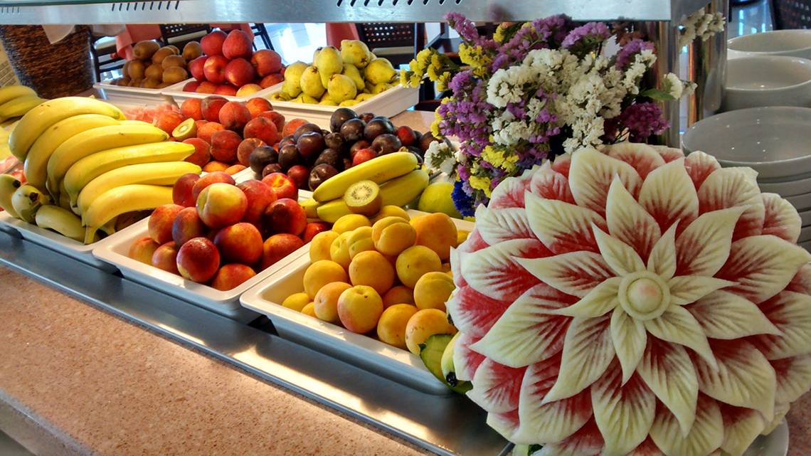 Früchtebuffet im Horizon Beach Resort mit verschiedenen Früchten und einer Wassermelonenblüte.