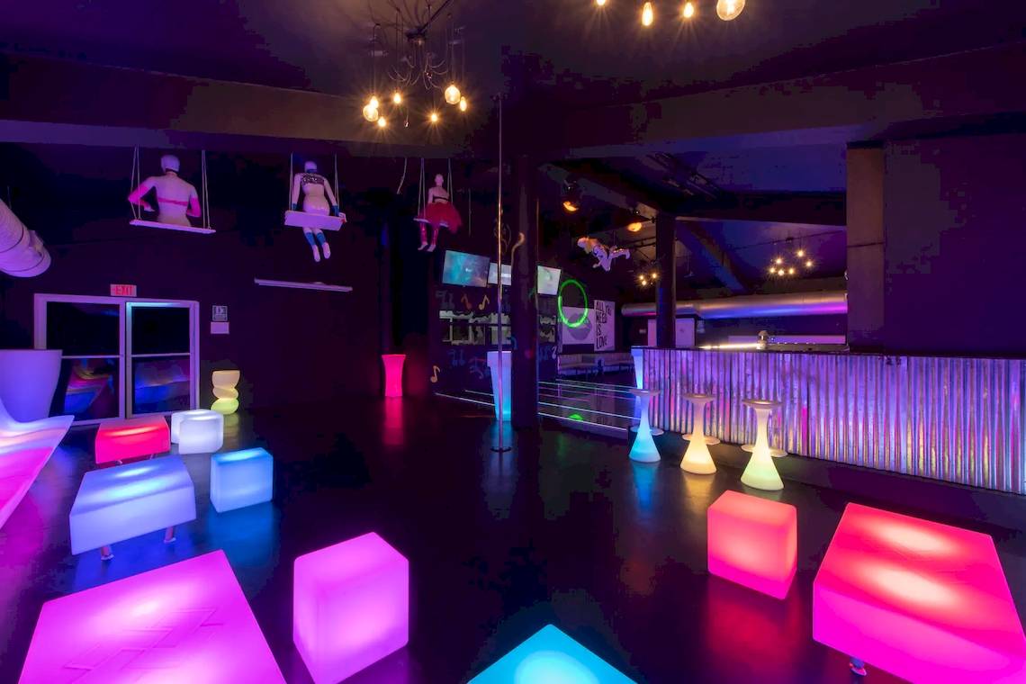 Loungebereich des Viva Wyndham V Heavens Hotels mit farbigen Möbeln und Lichteffekten.