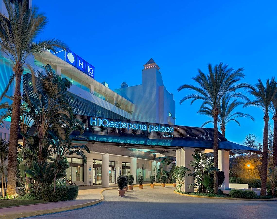 Eingang des H10 Estepona Palast Hotels mit Palmen und Beleuchtung