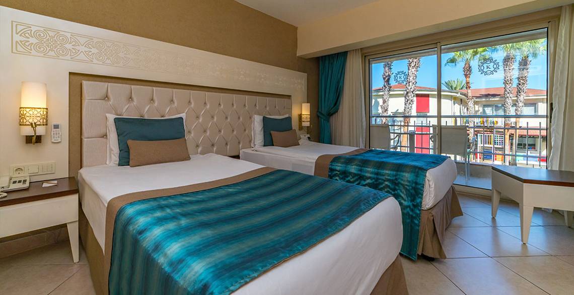 Hotelzimmer im Kamelya Aishen K Club mit zwei Betten, Veranda und Aussicht auf Palmen