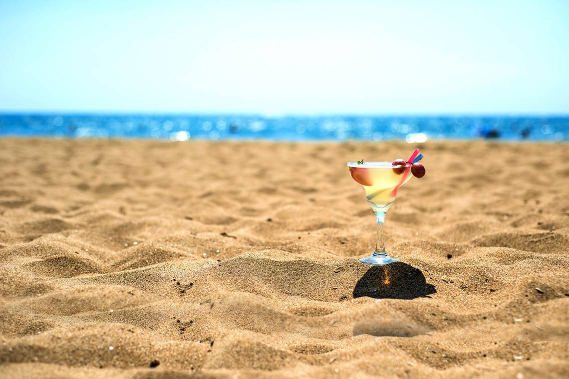 Ein Cocktailglas mit Früchten steht auf dem Strand vor dem Hotel Kamelya Aishen K Club.