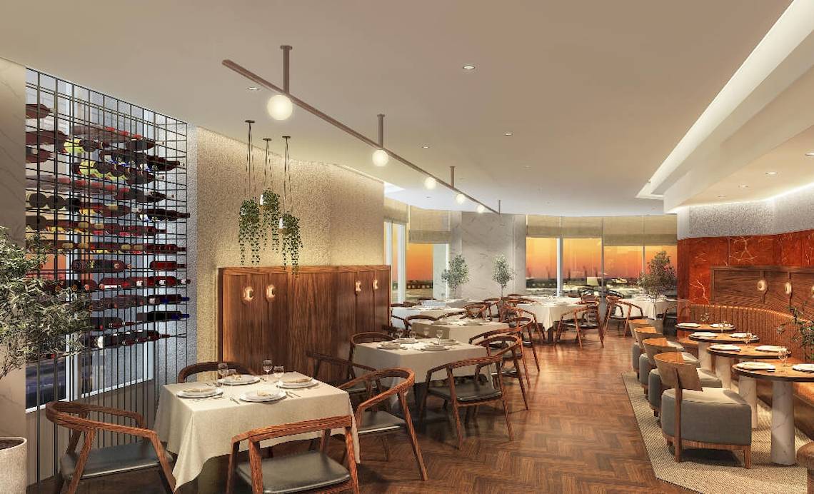 Innenansicht des JA Lake View Restaurants mit gedeckten Tischen, Stühlen und einer Weinflaschenwand.